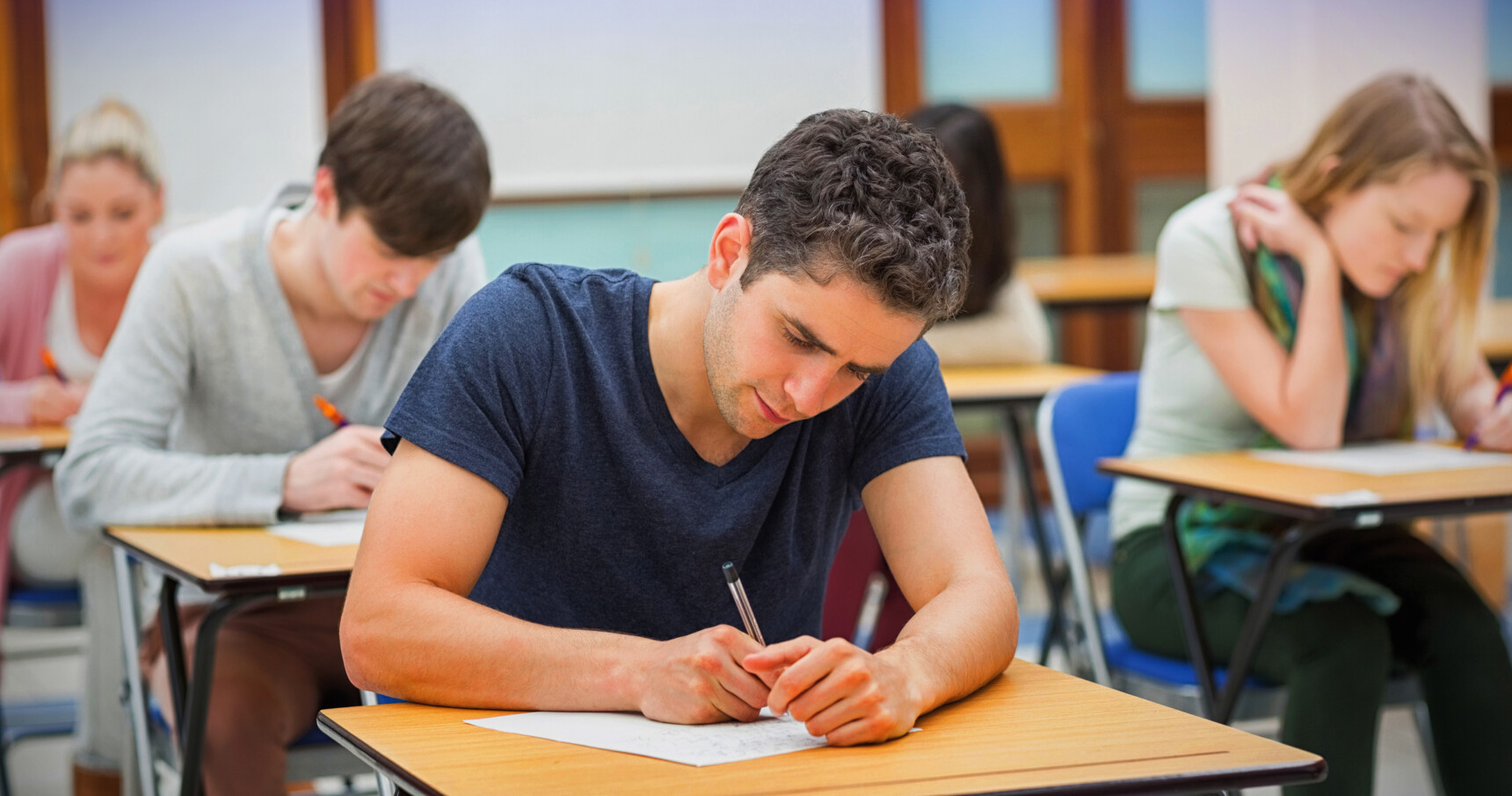 A male student is stitting an A Level exam