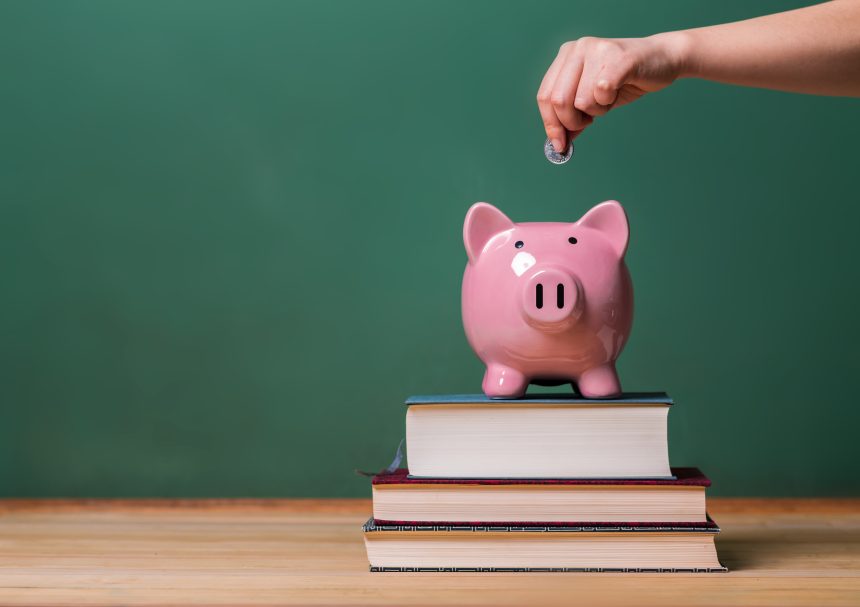 A student depositing money into a piggy bank.