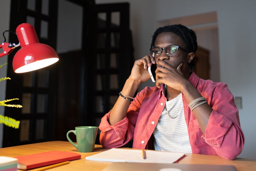 Male student on the phone to a university Clearing hotline.