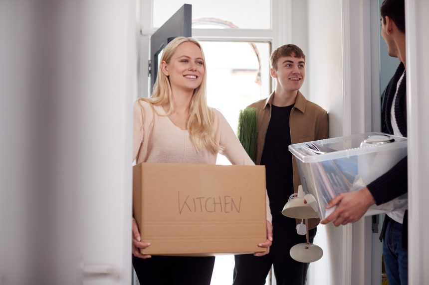 Three students moving into their university accommodation.