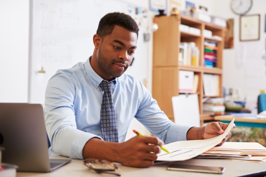 A new male secondary school science teacher planning his lessons.