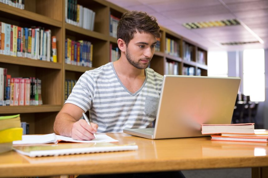 A male student revising in his school library.