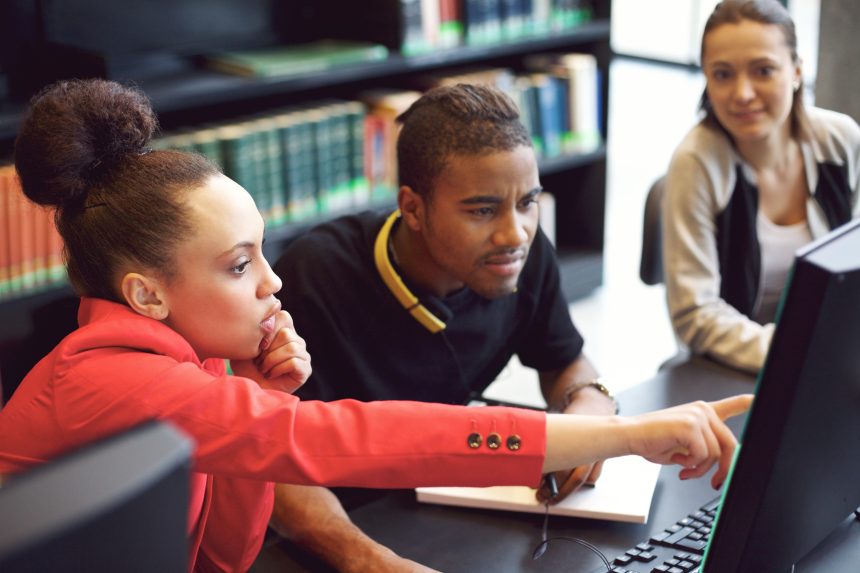 Three Sixth Form students researching UCAS Clearing universities.