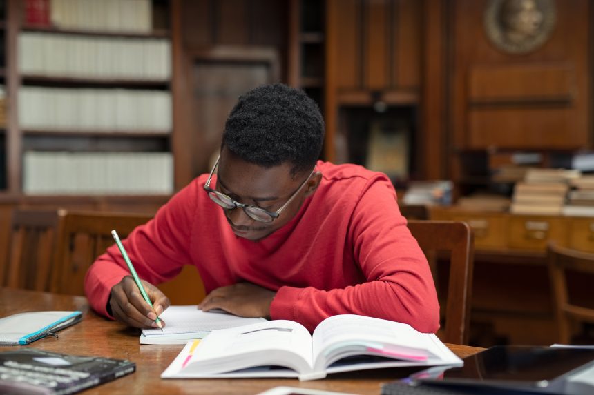 A male student studying in his university library.