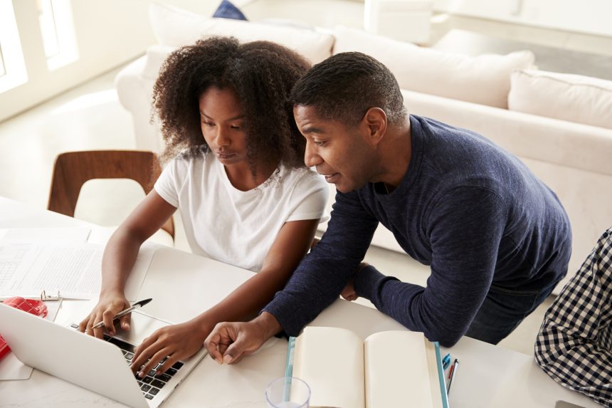 Father helping daughter with homework.