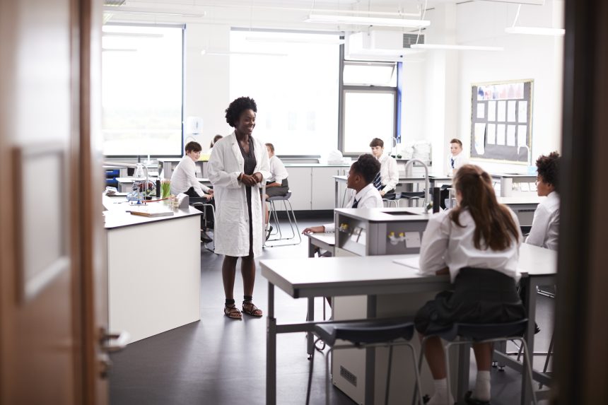 A female secondary school teacher teaching a science class.