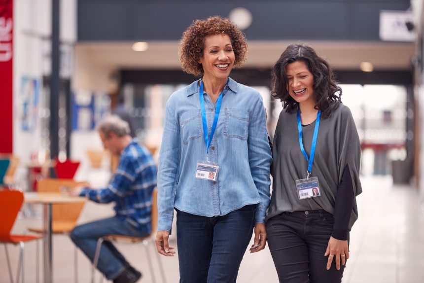 Two female teachers smiling and chatting.