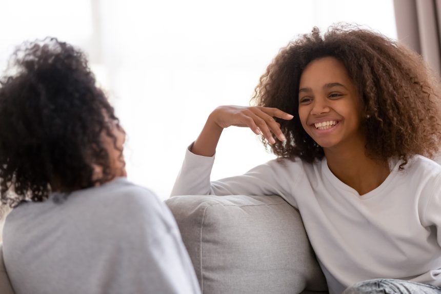 Mum and daughter chatting together and smiling.