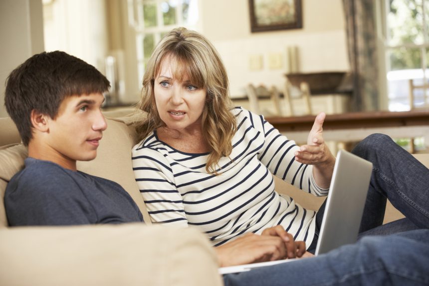 Mother helping her son research university courses.