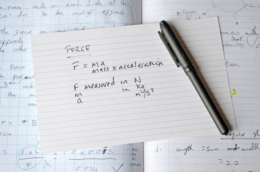 Physics revision flashcards and an exercise book.