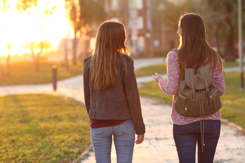 Two friends walking together in the park as a revision break.