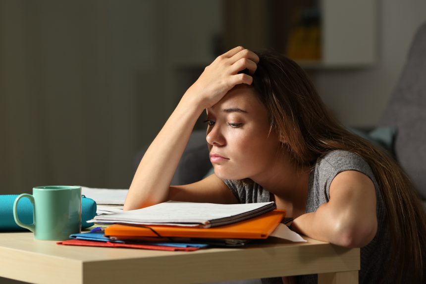 A student exhausted from her part-time job trying to study.