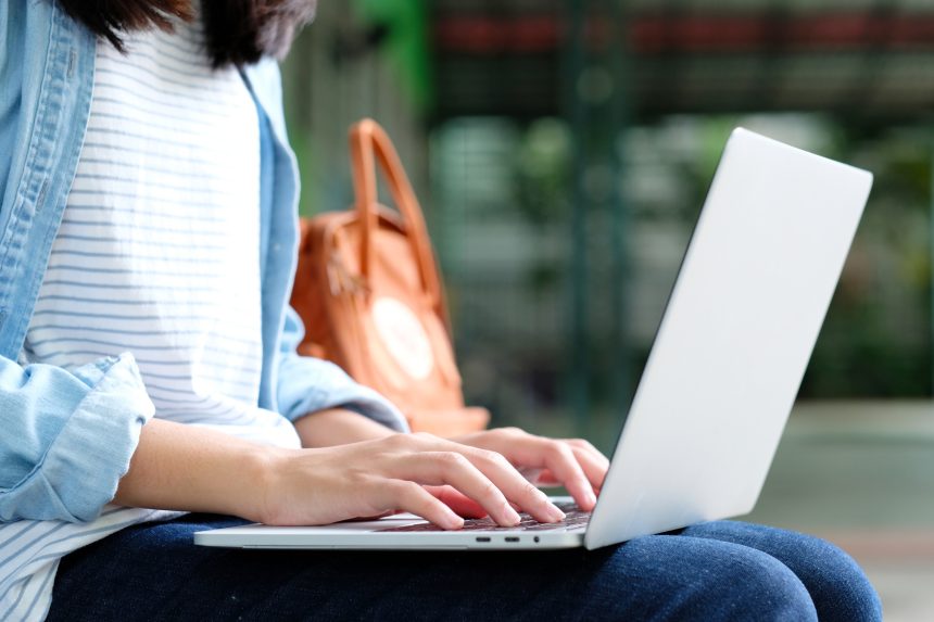 A female tutor responding to emails on her laptop.