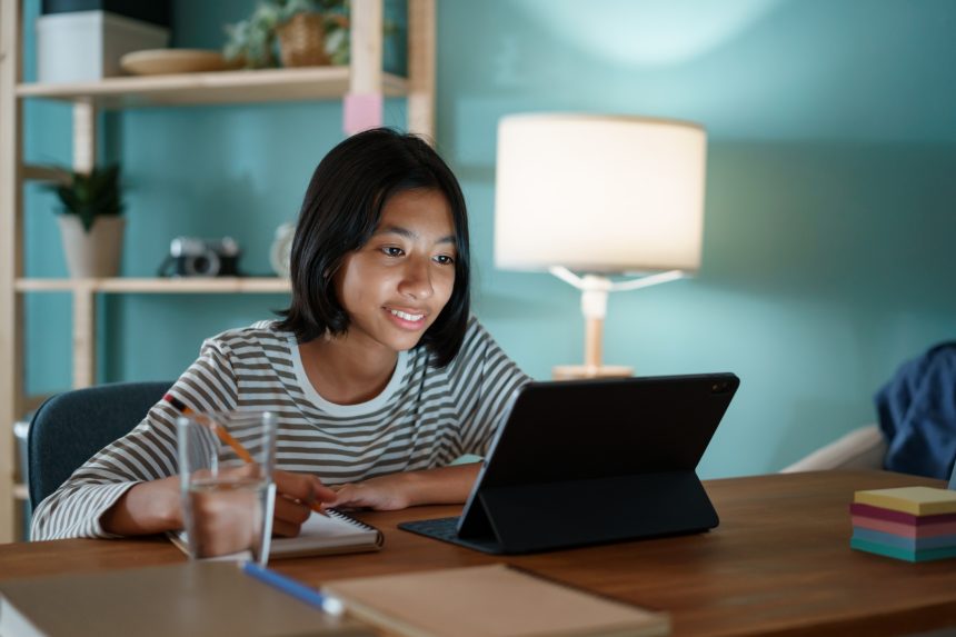 Young girl studying with her online tutor after school.