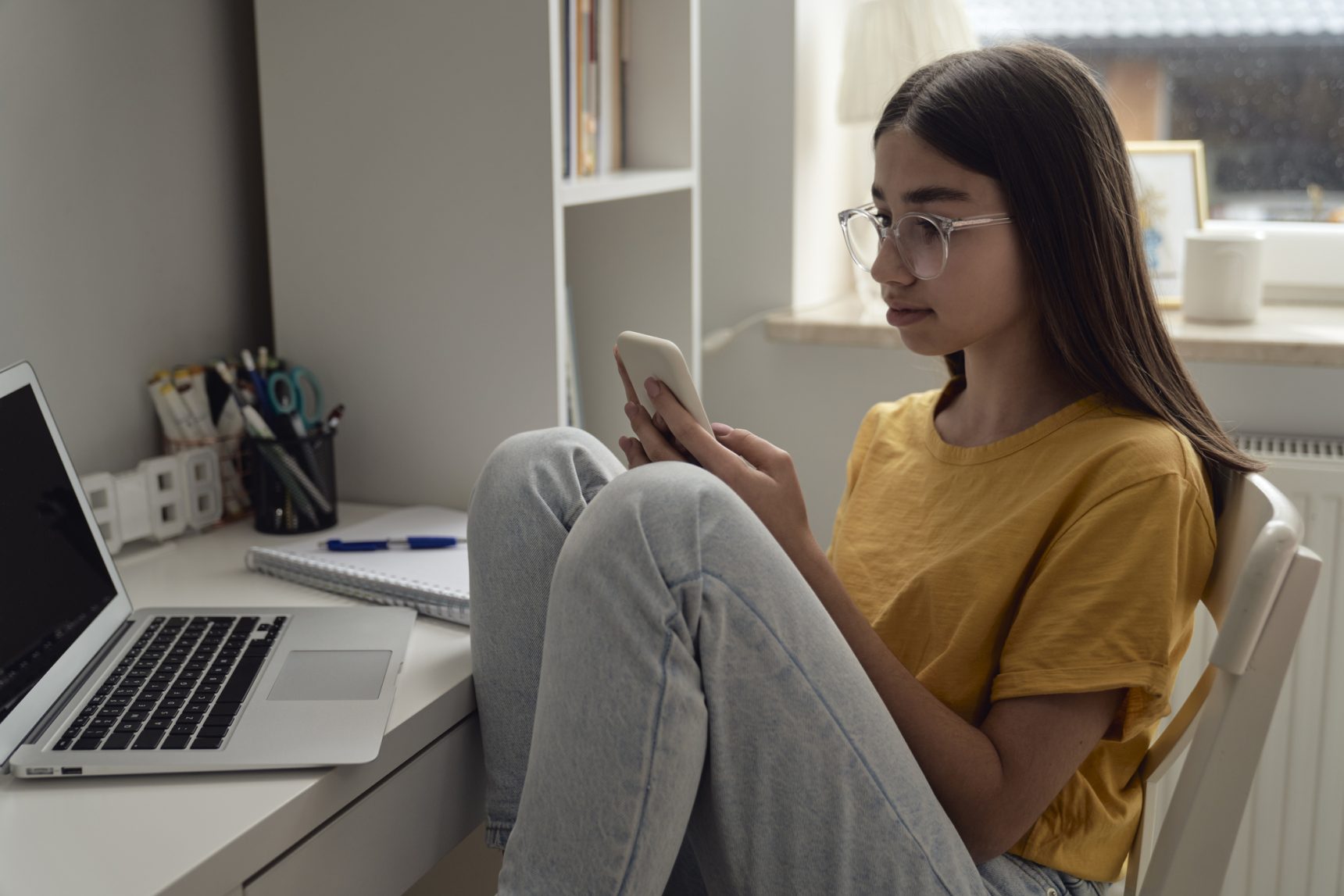 Teenage girl exploring revision apps on her spartphone.