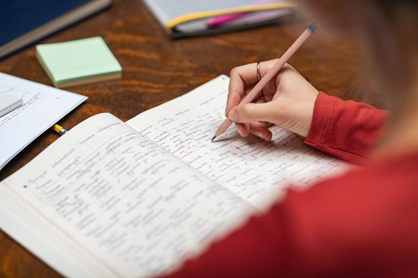 Student completing homework in exercise book.