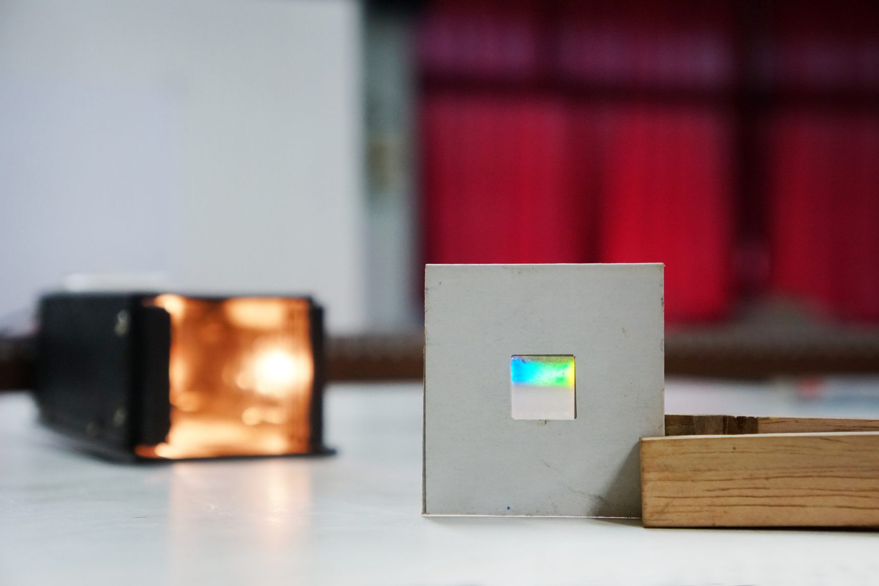 A diffraction grating sheet for studying the interference of visible light from a lamp.