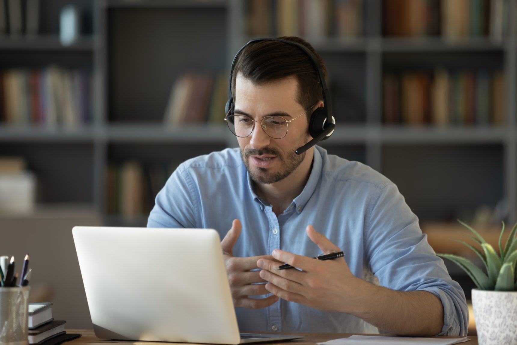 Male tutor wearing headphones with a built-in microphone.