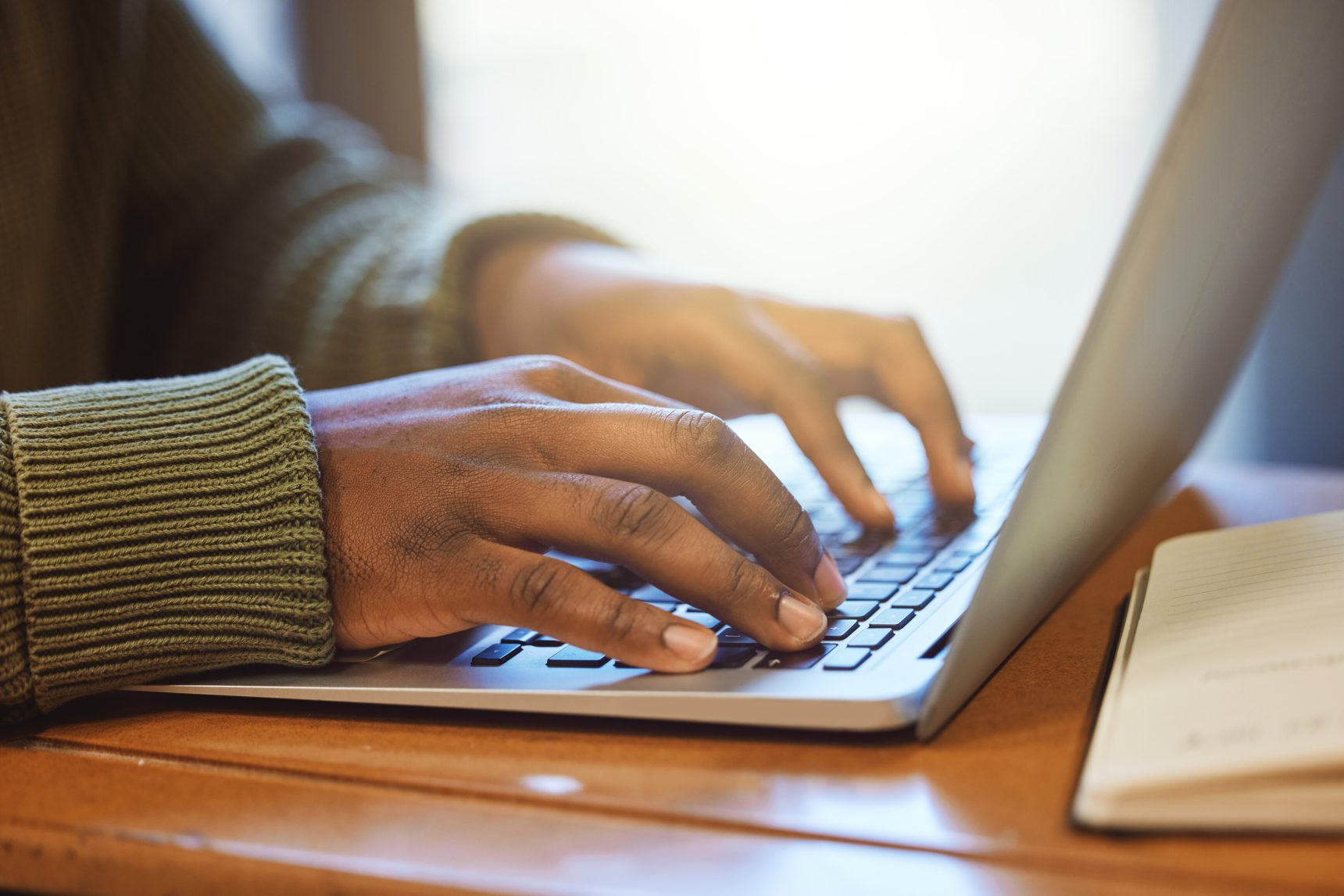 Hands typing on a laptop.