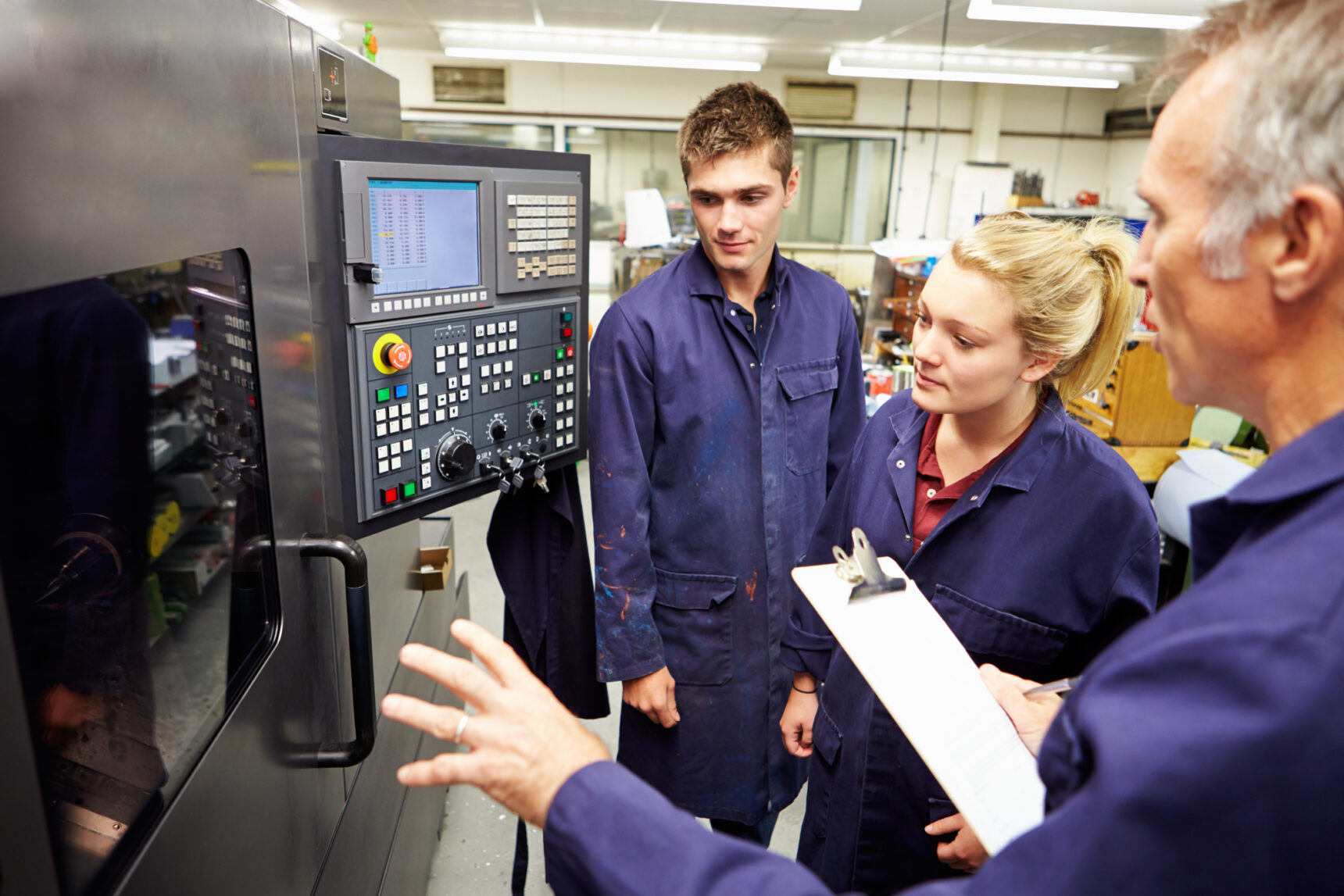 Students on an engineering apprenticeship are being shown how to use a CNC (Computer Numerical Control) lathe.