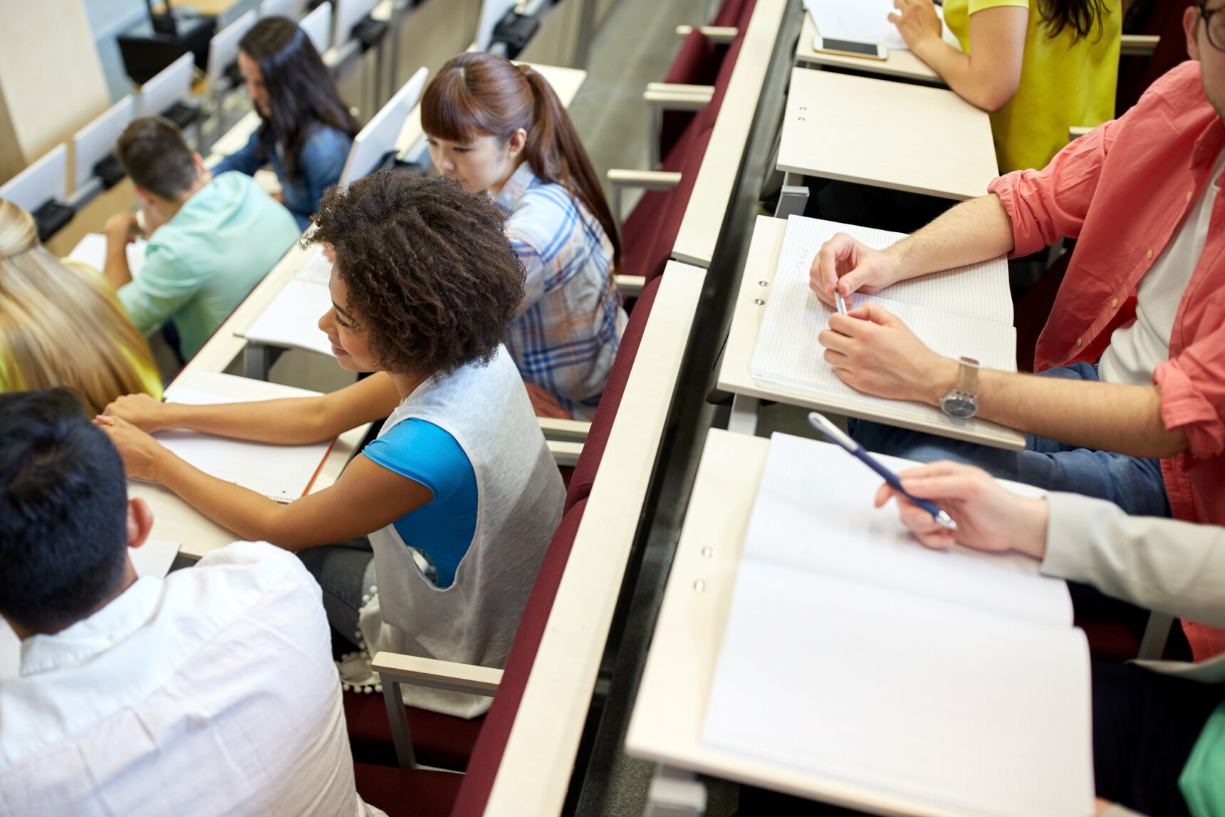 Students attending Freshers' Week welcome talk in lecture theatre.