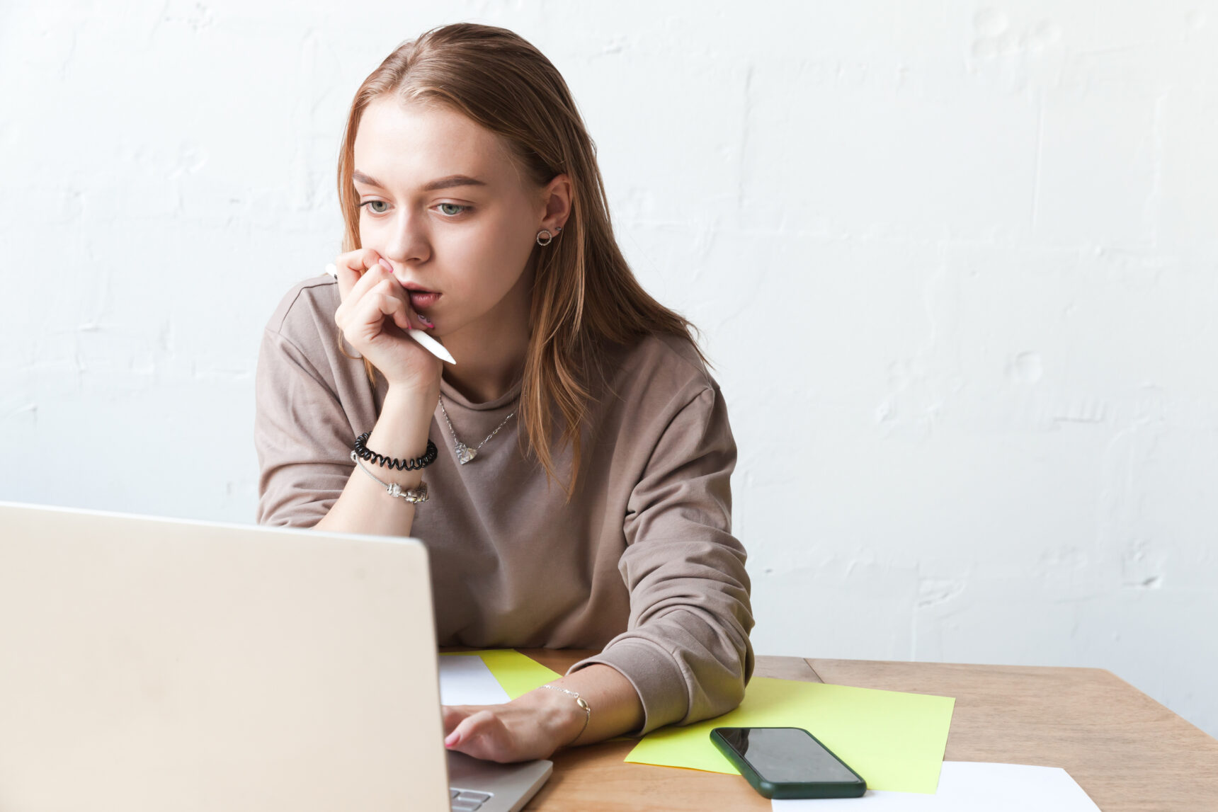 a female student is using ChatGPT on her laptop while doing homework.