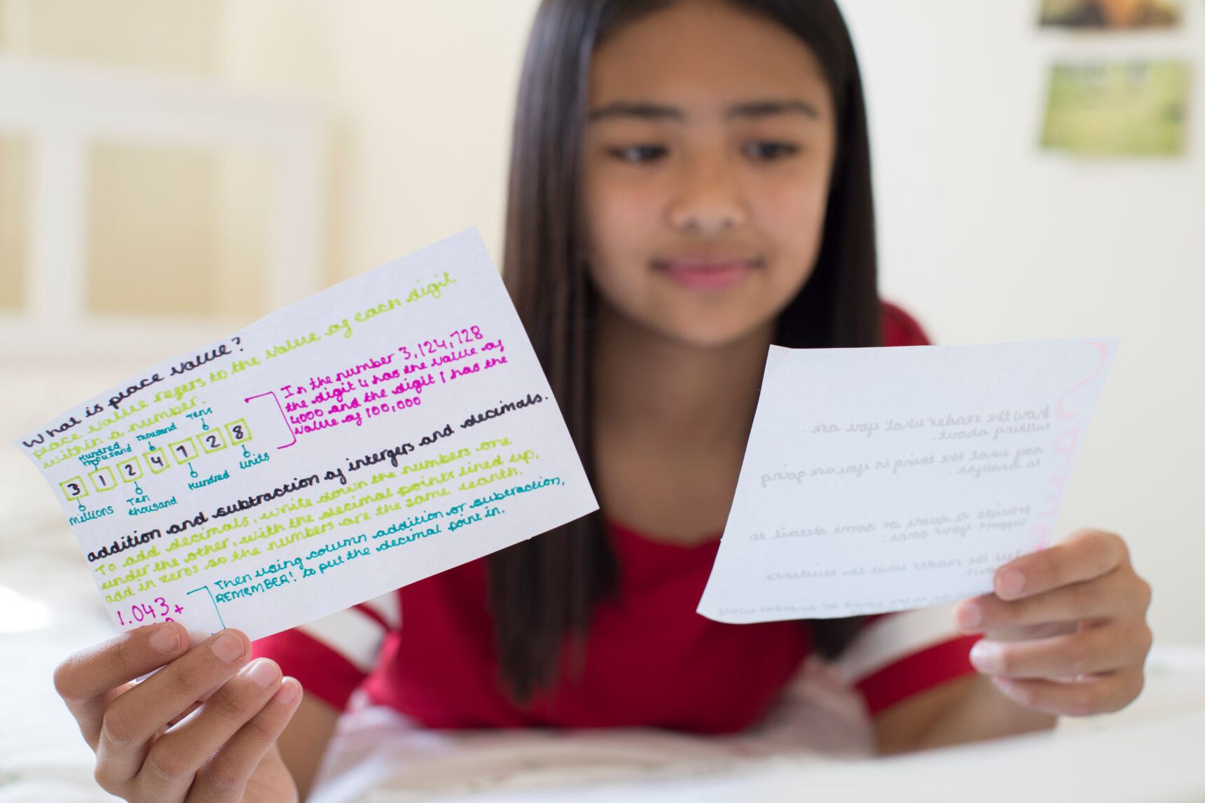A teenage girl using flashcards for active revision.
