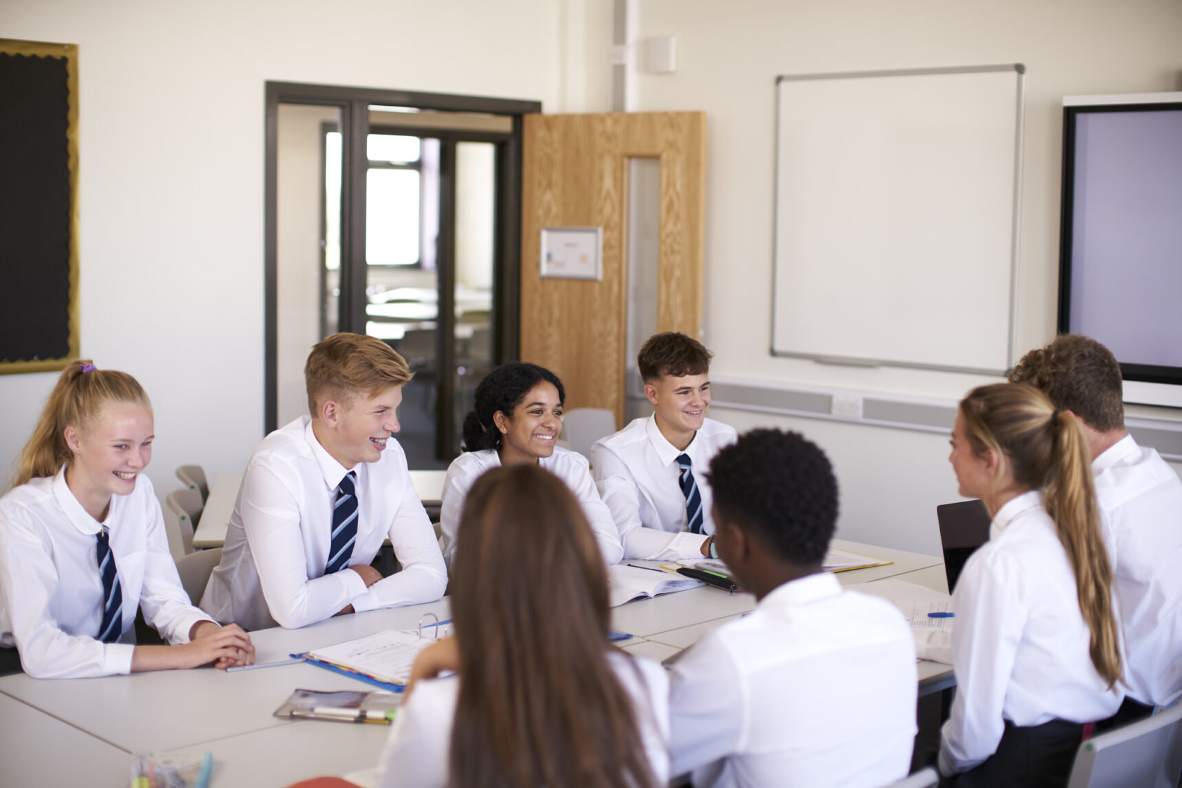 A small group of students are having a discussion in an English classroom.