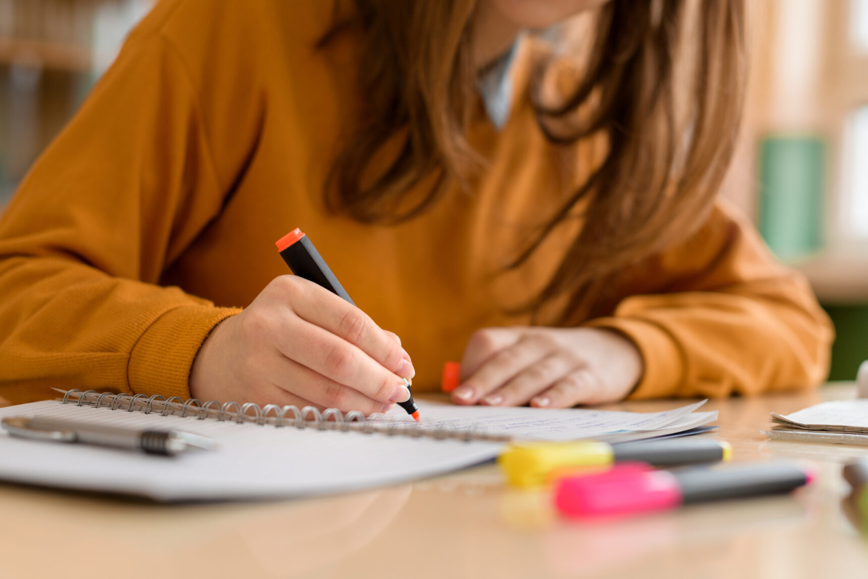 A teenage girl is highlighting text as she prepares for her GCSe English Language exam.