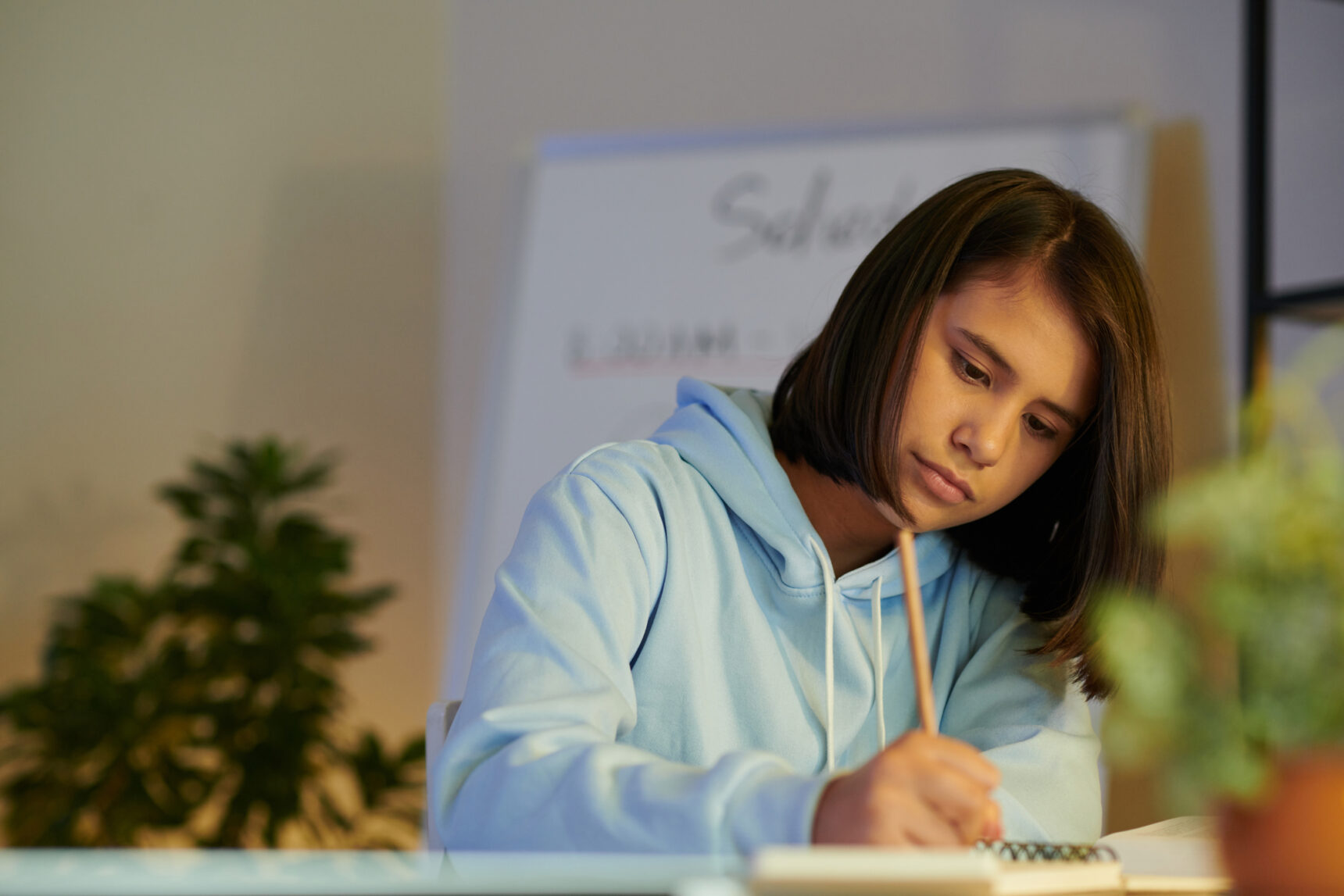 A teenage girl is preparing for her GCSE English Language exam by sitting a past paper.