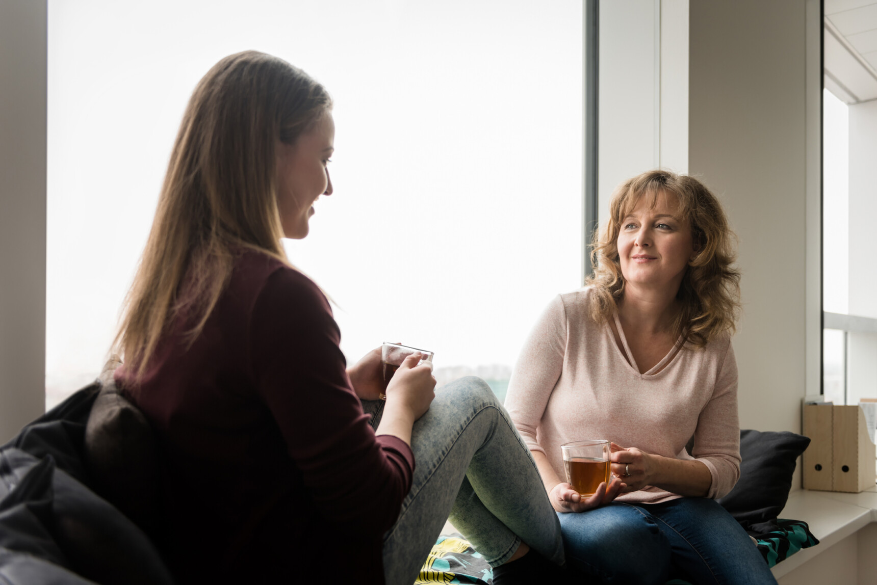 A mother and daughter are sitting drinking tea and chatting about how revision is going.