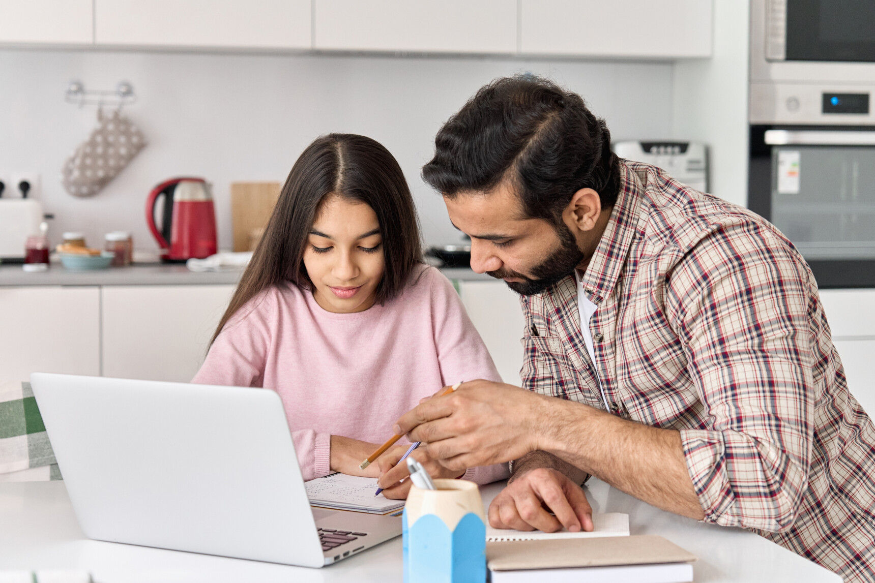 A dad is helping his home educated daughter to complee coursework.