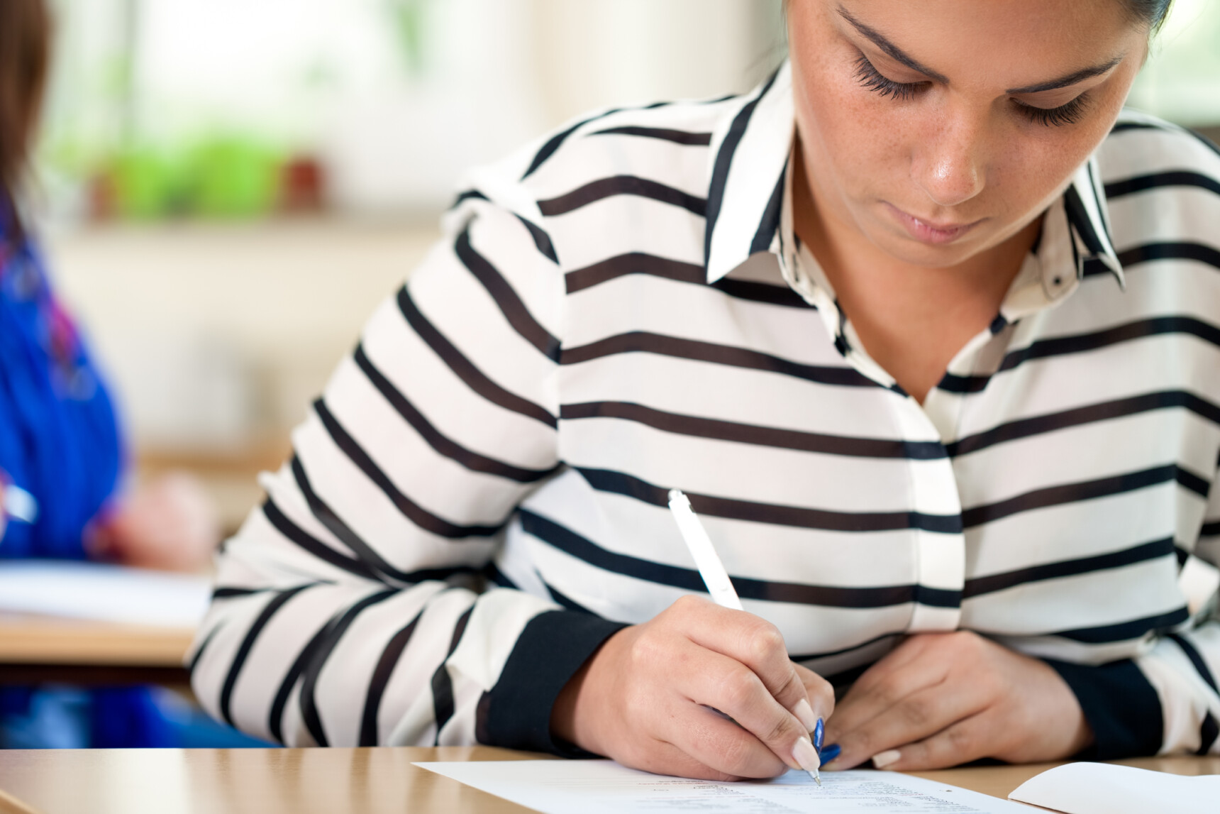 A female student is sitting a GCSE exam as a private candidate.