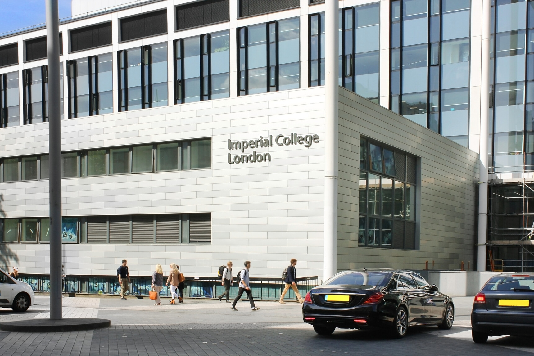 Exterior of Imperial College London with students walking past the university campus.